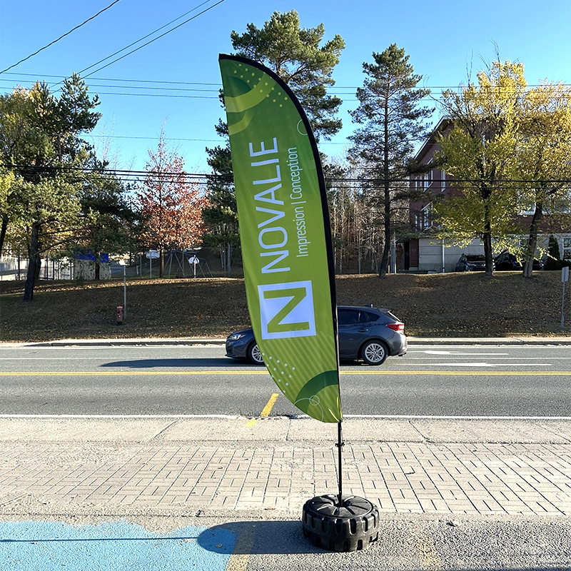 Drapeau publicitaire vert NOVALIE devant une rue