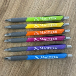 Six stylos Magister colorés sur table en bois