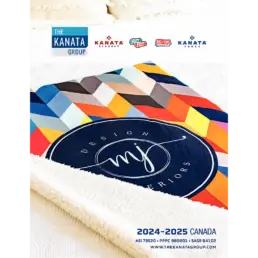 Couverture colorée Kanata sur un lit blanc.