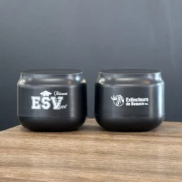 Deux gobelets noirs personnalisés sur une table en bois