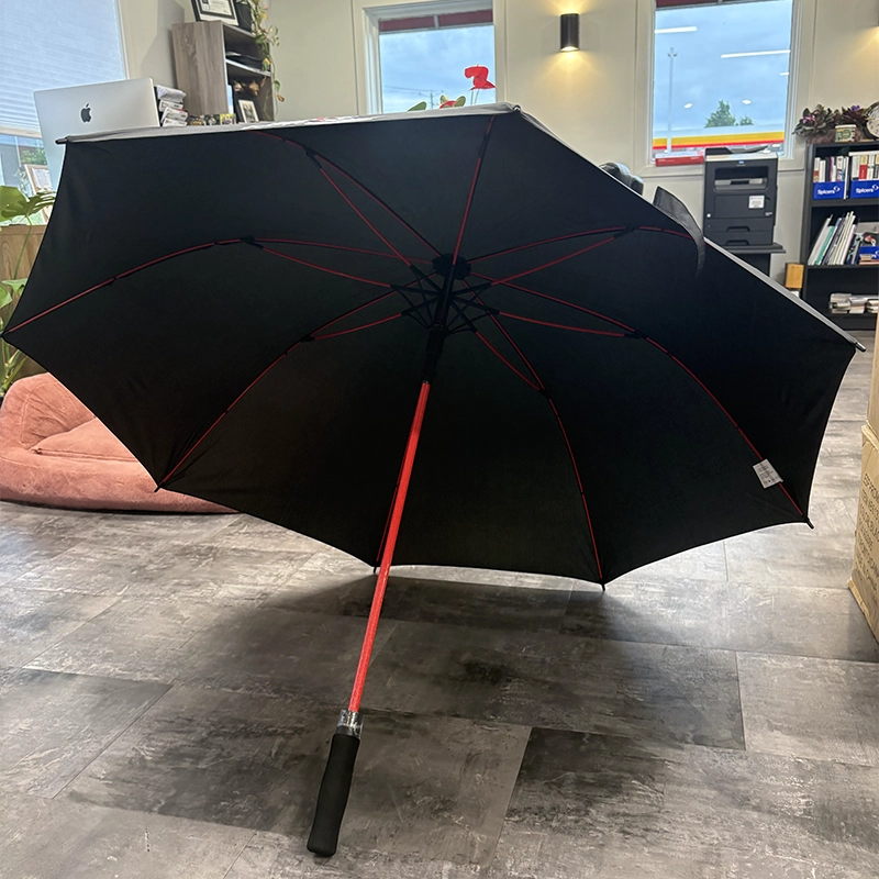 Parapluie noir ouvert à poignée et armature rouges